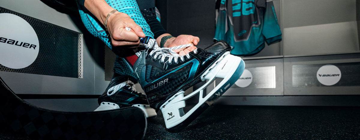 Bauer Supreme FUSE hockey skate being laced in the locker room