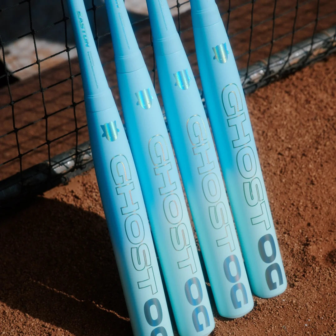 Four Easton Ghost OG fastpitch bats leaning against a backstop net