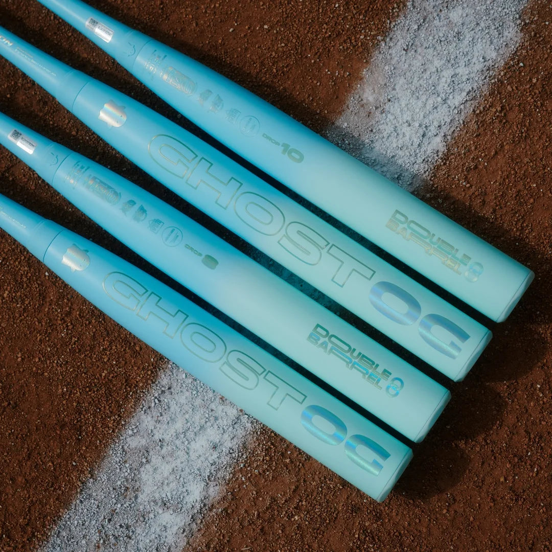 Four Easton Ghost OG fastpitch bats laid diagonally on infield dirt